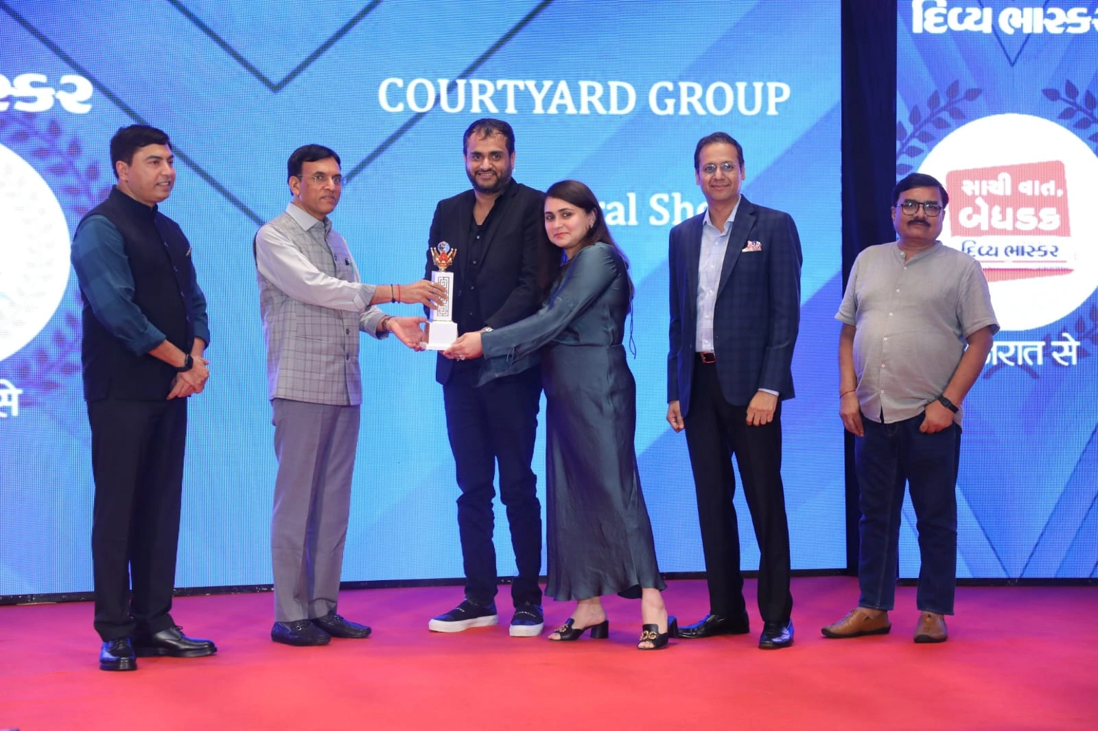 Courtyard Group team receiving Premium Construction Excellence Award for outstanding real estate development in Gujarat
